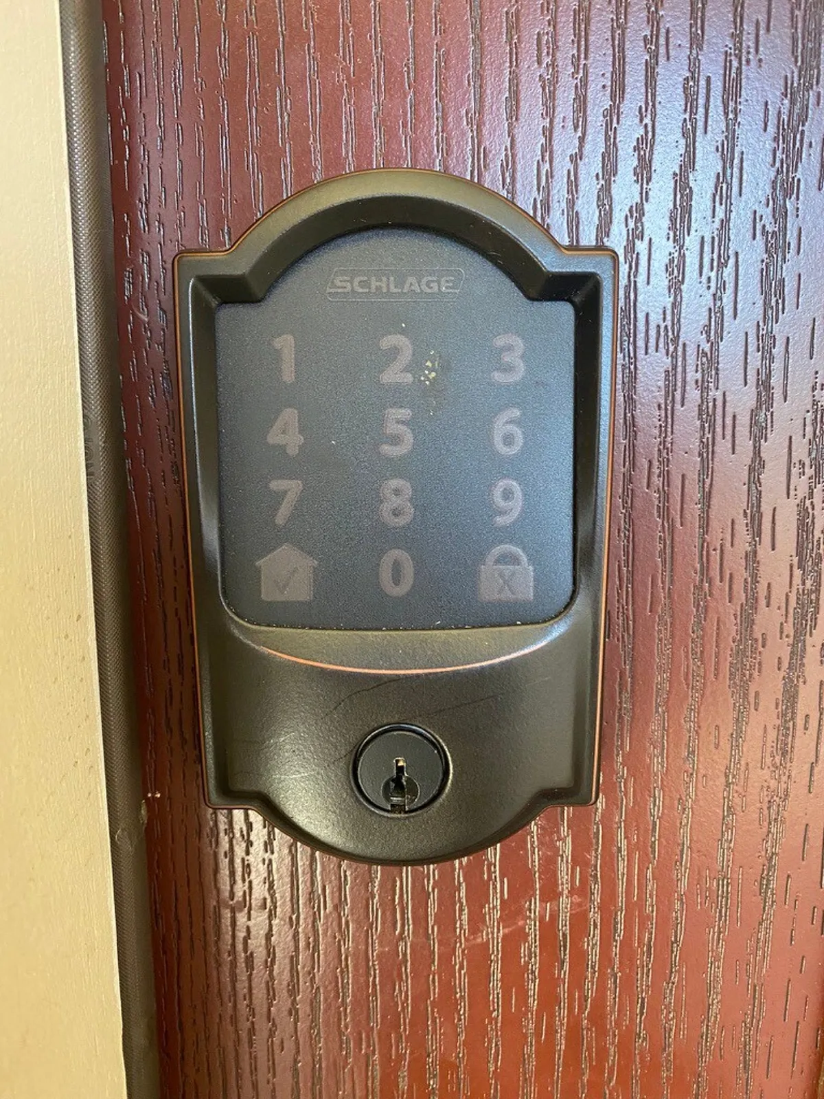 This image features a modern wooden door with a keypad lock, hinting at the entrance to the property. The focus on the keypad and door texture suggests both security and a welcoming first impression for arriving groups.